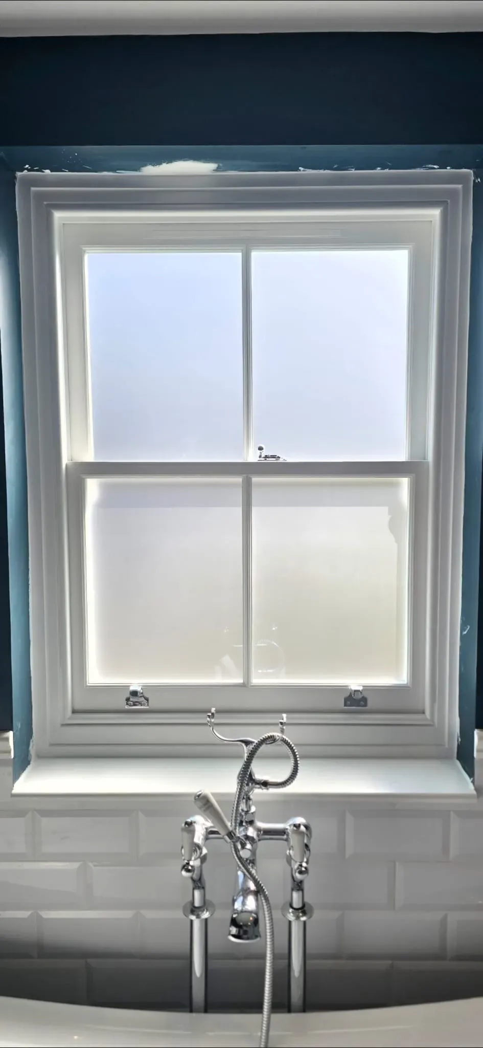 Bespoke timber sash window with two-over-two glazing bars and chrome sash lifts installed in a period bathroom