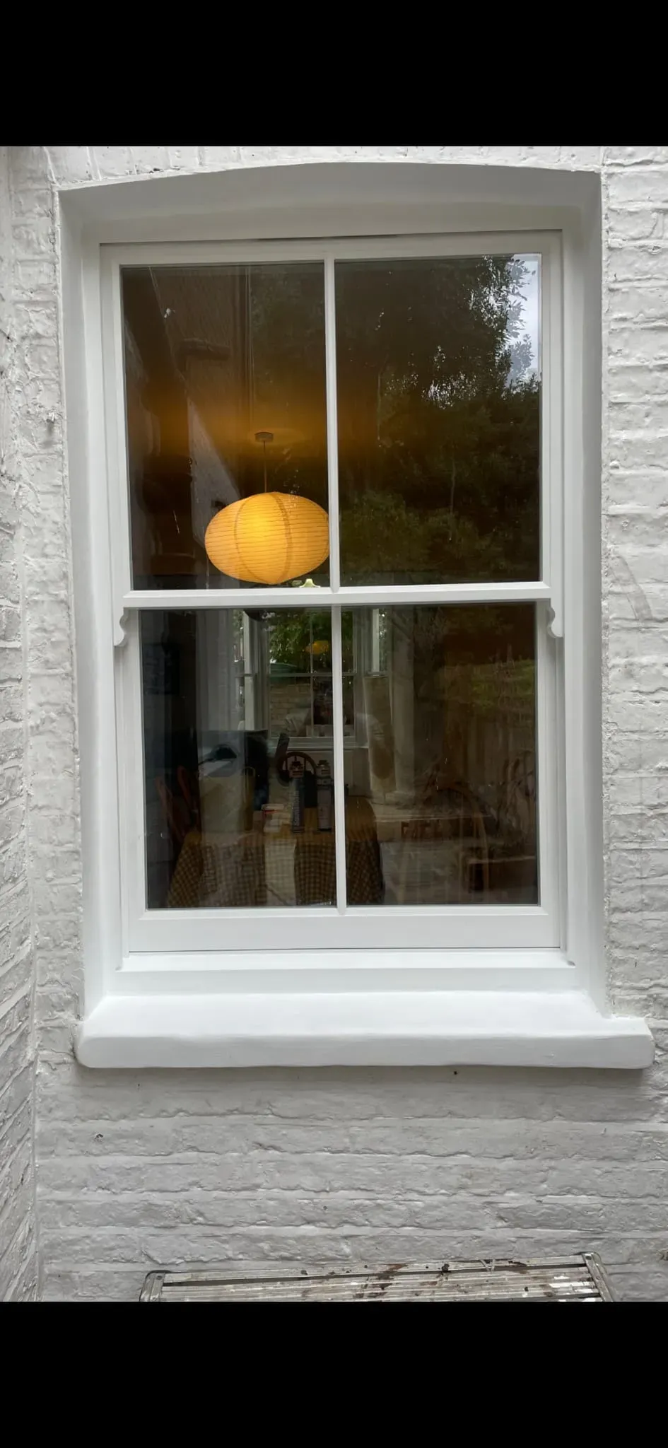 Restored Victorian timber sash window with authentic horns and slimline glazing in a painted brick reveal