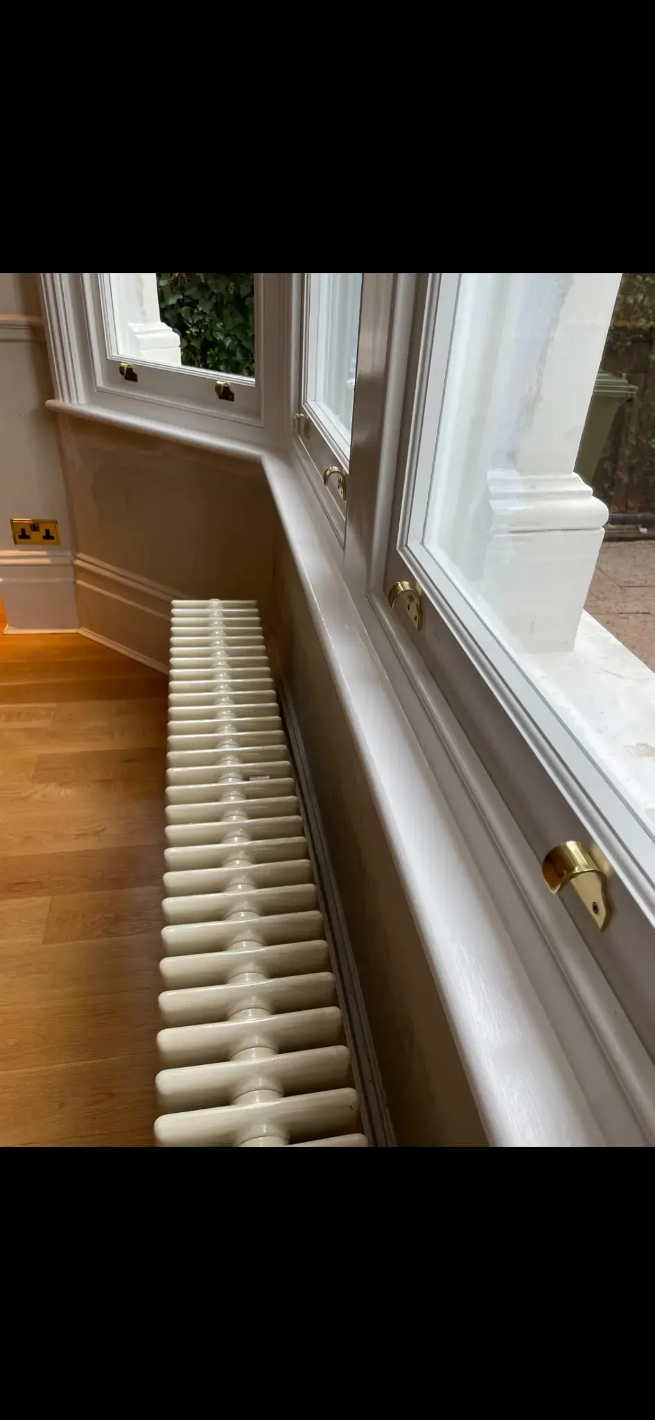 Bespoke timber sash bay windows with brass lifts and painted sills in a period home