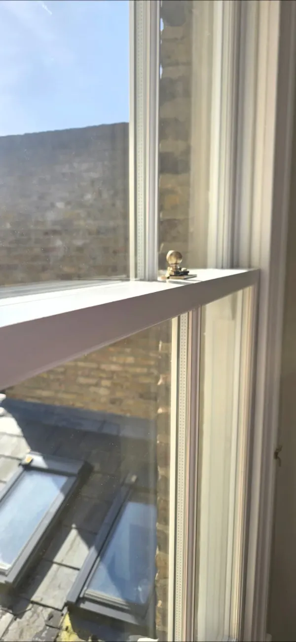 Double glazed timber sash window meeting rail with brass fastener